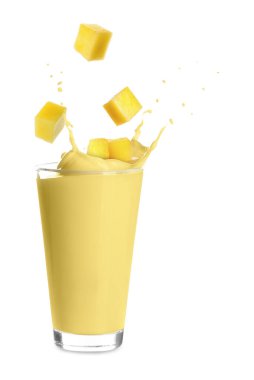 Mango milkshake ve beyaz arka planda taze meyve parçaları