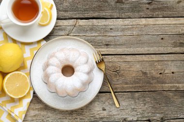 Lezzetli limonlu pasta pudra şekerli, taze meyve ve ahşap masada çay, düz yatak. Metin için boşluk