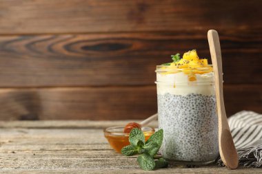 Mangolu lezzetli chia pudingi ve ahşap masada nane şekeri, metin için yer var.