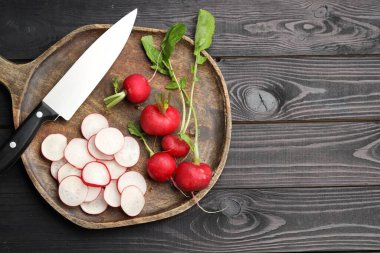 Bir sürü taze turp ve bıçak, siyah ahşap masa, üst manzara. Metin için boşluk