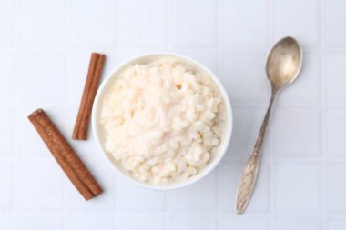 Beyaz fayanslı masada servis edilen tarçınlı lezzetli sütlaç.