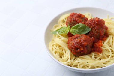 Beyaz fayanslı masada köfteli makarna, yakın plan. Metin için boşluk