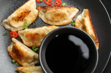 Kızarmış gyoza köftesi, yeşil soğan, kırmızı biber ve soya sosu.