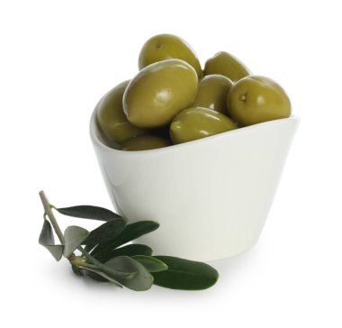 Lezzetli terbiye edilmiş yeşil zeytinler kasede ve beyaz yapraklar