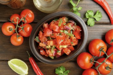 Ahşap masadaki malzemelerle nefis baharatlı salsa sosu.