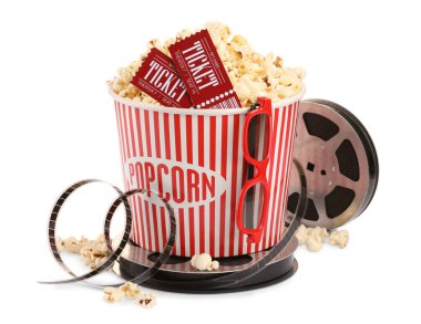 Lezzetli patlamış mısır, film makarası, bardaklar ve sinema biletleri beyaza izole edilmiş.