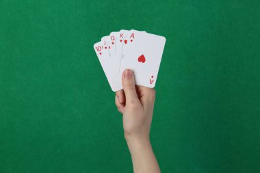 Yeşil arka planda kart oynayan kadın, yakın plan