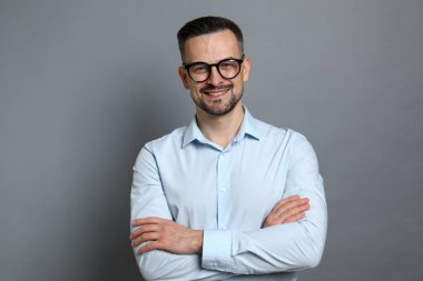 Gri arka planda orta yaşlı yakışıklı bir adamın portresi.