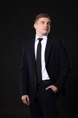 Siyah arka planda klasik takım elbiseli adam.