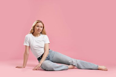 Pembe arka planda şık kotlu gülümseyen kadın. Metin için boşluk