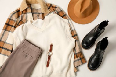 Beyaz arka planda şık kıyafetler, botlar ve aksesuarlar, düz yatış