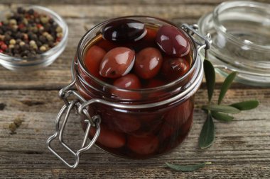 Cam kavanozda turşu ve ahşap masada baharatlar, yakın plan.