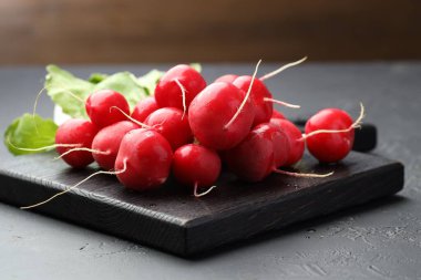 Koyu dokulu masada bir sürü taze turp, yakın plan.