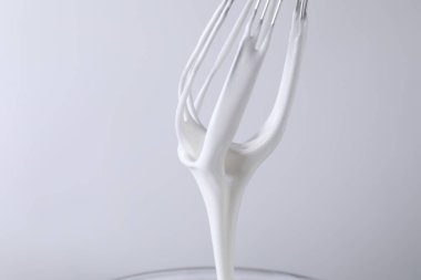 Beyaz arka planda krem şantili çırpma çırpma, yakın plan