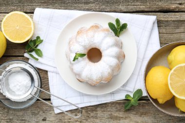 Lezzetli limonlu pasta pudra şekerli, taze meyveli ve nane şekerli ahşap masa, düz uzanmış.