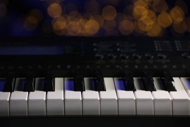 Piyano bulanık ışıklara karşı, yakın plan. Bokeh etkisi