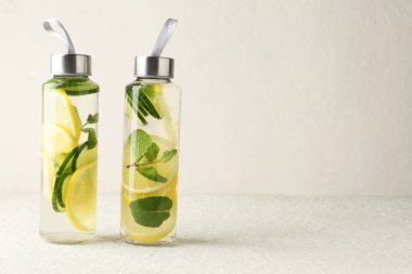 Nane aromalı limon suyu ve bej masadaki salatalık dilimleri, metin için yer.