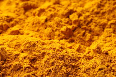 Aromatic turmeric powder as background, closeup view