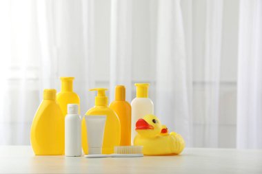 Bebek kozmetik ürünleri, fırça ve lastik ördekler açık ahşap masa içinde. Metin için boşluk