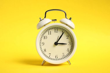 Sarı arkaplanda bir beyaz alarm saati