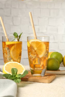 Pipet, nane, limon ve limon ile buzlu çayı yeşil arka planda dokuma masasında tazeliyorum.