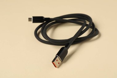Bej arka planda bir USB şarj kablosu, yakın plan