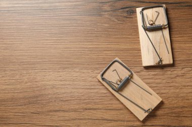 Two spring-loaded bar mousetraps on floor, flat lay. Space for text clipart