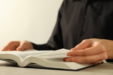 Bej masada İngilizce İncil okuyan kadın, yakın plan.