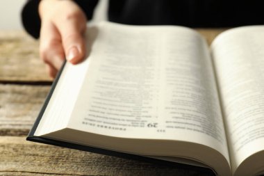 Kutsal İncil 'i İngilizce olan kadın ahşap masada, yakın plan.