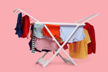 Açık pembe arka planda temiz çamaşırlı kuru askı.