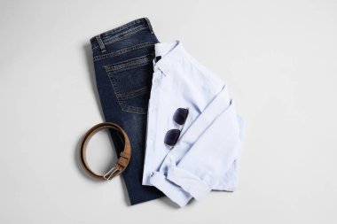 Açık gri arka planda şık kıyafetler ve aksesuarlar, düz yatış