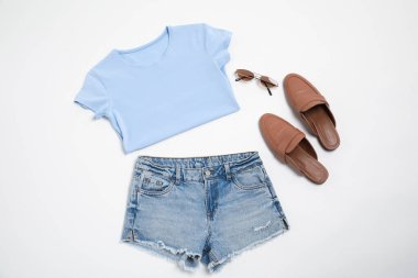 Beyaz arka planda şık kıyafetler, ayakkabılar ve güneş gözlükleri, düz yatış