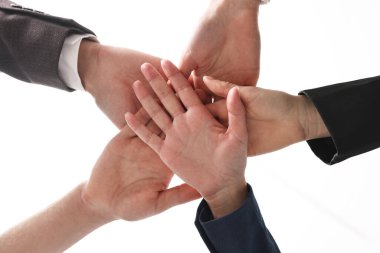Takım çalışması. Bir grup insan kapalı alanda el ele tutuşuyor.