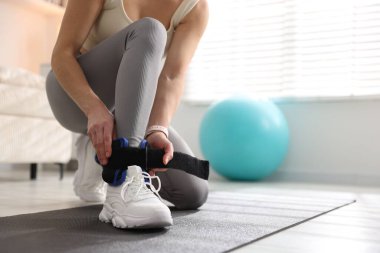 Spor salonunda bilek ağırlığı takan kadın, yakın plan.