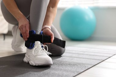 Spor salonunda bilek ağırlığı takan kadın, yakın plan.