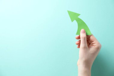 Turkuaz arka planda kağıt oklu kadın, üst manzara. Metin için boşluk