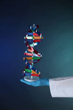 Koyu mavi arka planda DNA yapısına sahip bilim adamı, yakın plan