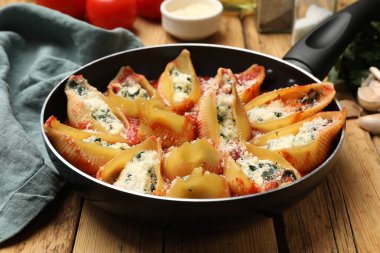 Tahta masada servis edilen ricotta ve ıspanakla doldurulmuş lezzetli kabuklu makarna.