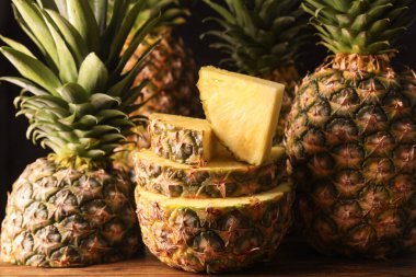 Ahşap masa üzerinde tüm ve kesme olgun ananas