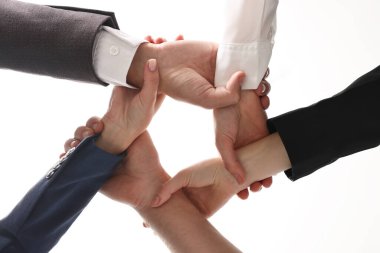 Takım çalışması. Bir grup insan kapalı alanda el ele tutuşuyor.