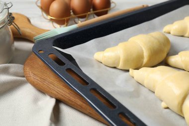 Tahta masada çiğ kruvasan ve yumurta, yakın plan.