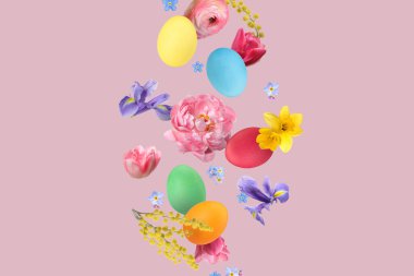 Paskalya yumurtaları ve pembe arka planda uçan güzel bahar çiçekleri.