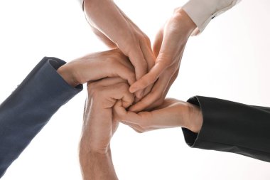 Takım çalışması. Bir grup insan kapalı alanda el ele tutuşuyor.