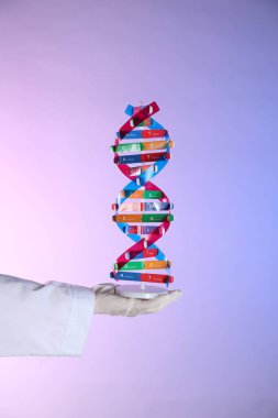 Renk arkaplanı üzerinde DNA yapı modeline sahip bilim adamı, yakın plan
