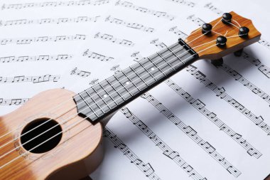 Müzik sayfaları üzerinde bir ukulele, yakın çekim görünümü