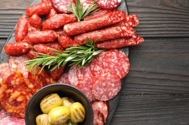 Farklı tütsülenmiş sosis, zeytin ve biberiye, ahşap masa, üst manzara. Metin için boşluk