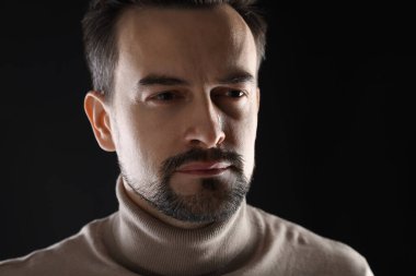 Siyah arka planda ağlayan üzgün bir adamın portresi