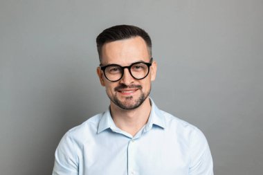 Gri arka planda orta yaşlı yakışıklı bir adamın portresi.