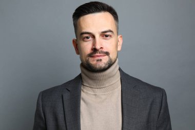 Gri arka planda orta yaşlı yakışıklı bir adamın portresi.