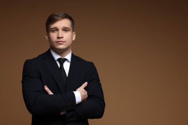 Kahverengi arka planda klasik takım elbiseli bir adam. Metin için boşluk